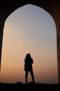 Silhouette man standing at sunset