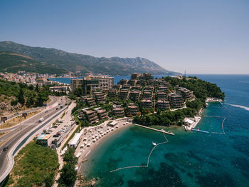 High angle view of sea and buildings against clear sky