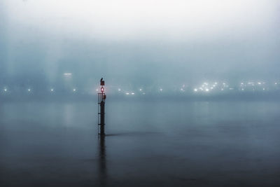 Lighthouse on sea against sky