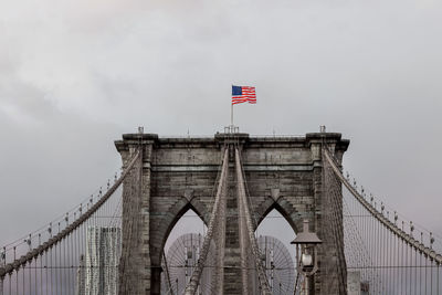 Low angle view of suspension bridge against sky