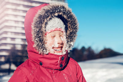 Close-up of cheerful girl with snow covered face