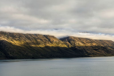 Scenic view of land and mountains against sky