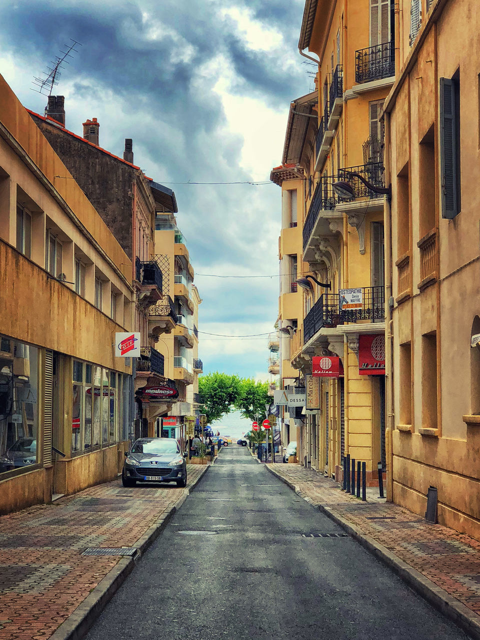 EMPTY ROAD BY BUILDINGS IN CITY