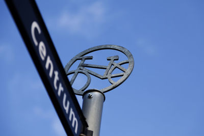 Low angle view of metal against blue sky