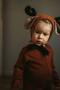 Portrait of toddler baby girl in rudolph reindeer costume. christmas concept christmas tree