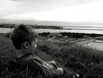 Boy on shore against sky