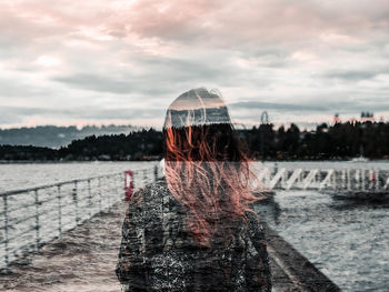 Double exposure image of woman with sea against sky