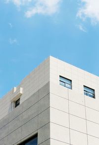 Low angle view of modern building against blue sky