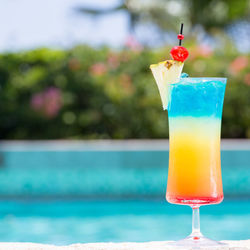 Close-up of drink on table against swimming pool