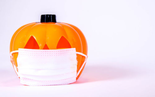 Close-up of orange bottle against white background