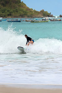 Full length of man splashing water in sea