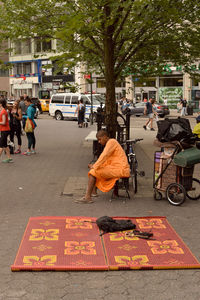 People sitting on street in city