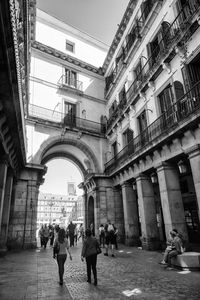 Group of people walking between historic buildings at plaza mayor in madrid