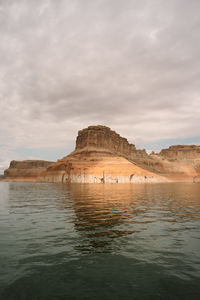 Red sandstone cliffs reflected into the waters of lake powell, utah