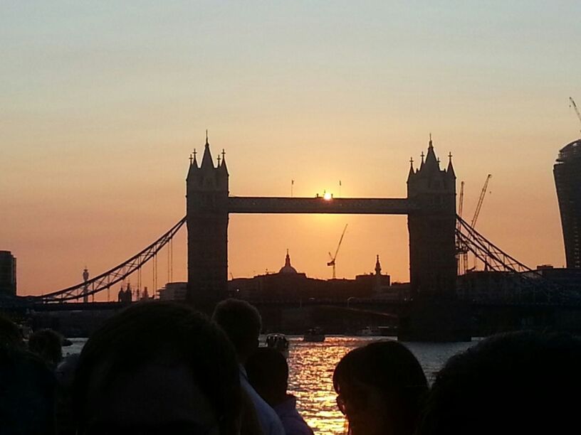 architecture, built structure, sunset, bridge - man made structure, connection, building exterior, city, transportation, silhouette, river, engineering, suspension bridge, international landmark, famous place, sky, travel destinations, orange color, bridge, clear sky, travel