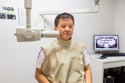 Mature man examined by dental equipment