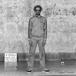 Portrait of young man standing against wall