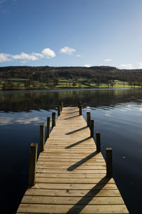 Pier over lake against sky