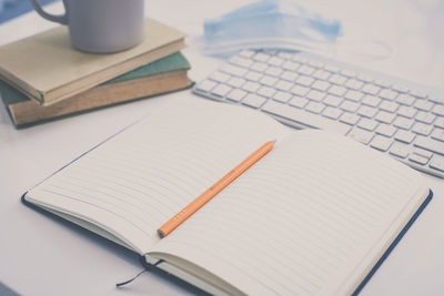 Desktop with keyboard, pencil, agenda, books. table with objects for smart working or homeschooling