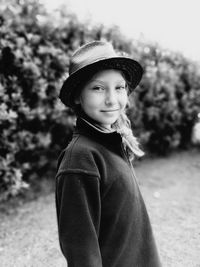 Portrait of cute girl wearing hat while standing against trees and sky