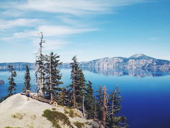 Scenic view of lake and mountains against blue sky