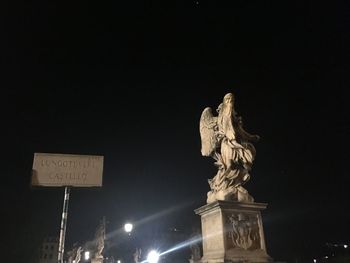 Low angle view of statue against sky at night