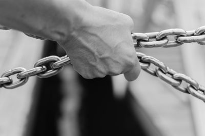 Close-up of hand holding chain