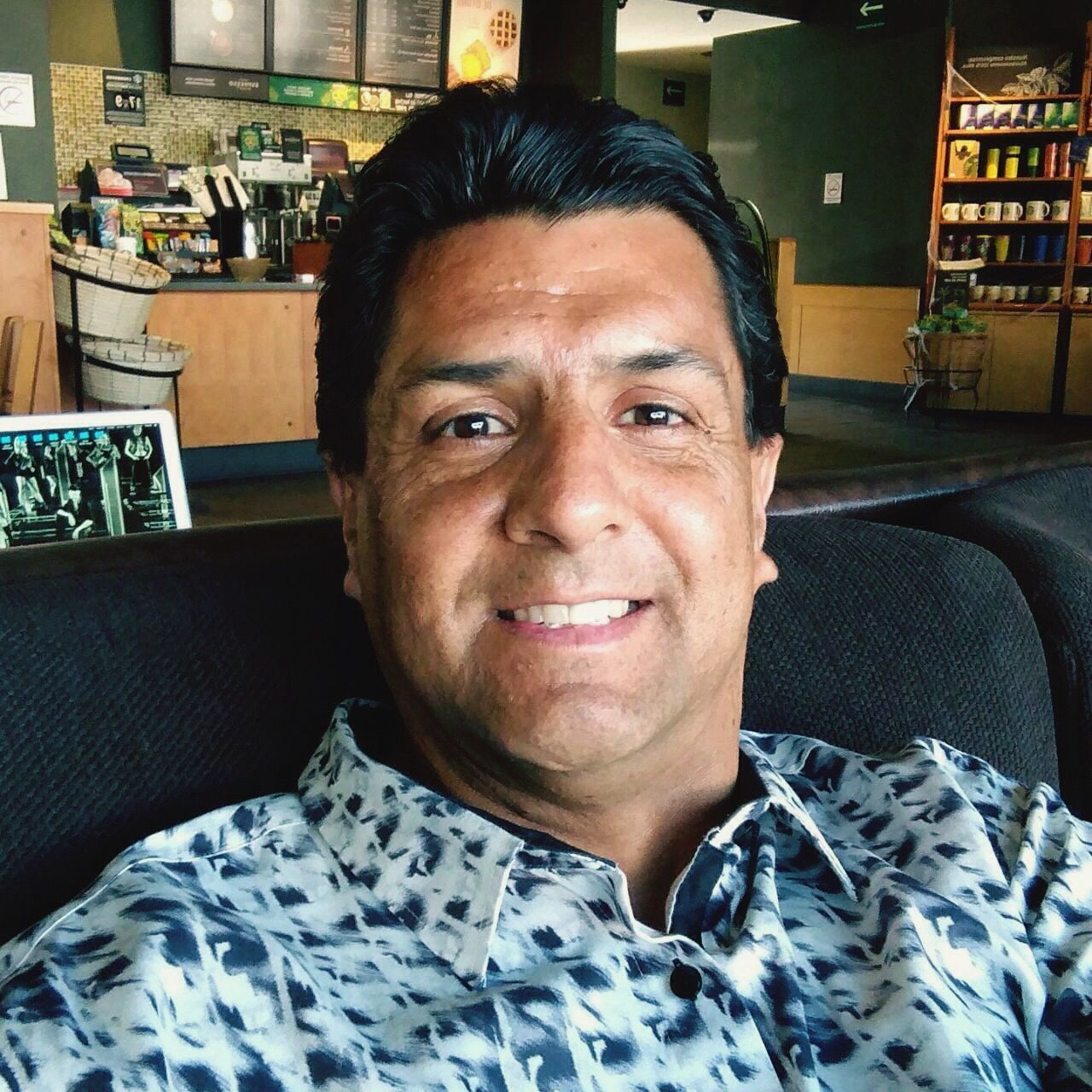 PORTRAIT OF A SMILING YOUNG MAN SITTING