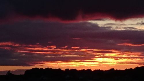 Silhouette of landscape against cloudy sky