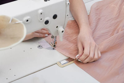 High angle view of woman stitching clothes