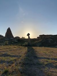 Rock formations on landscape against sky during sunset