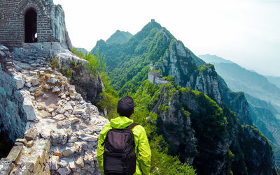 Rear view of man with back pack looking at great wall of china