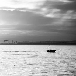 Boat sailing in sea at sunset