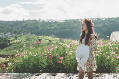 Woman standing by flowering plants