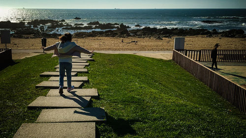 Rear view of woman standing on beach