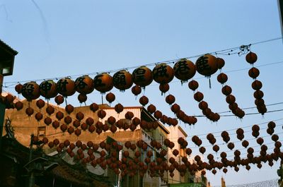 Low angle view of lanterns hanging against sky