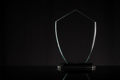 Close-up of trophy on table against black background