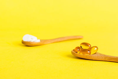 High angle view of pills on yellow background