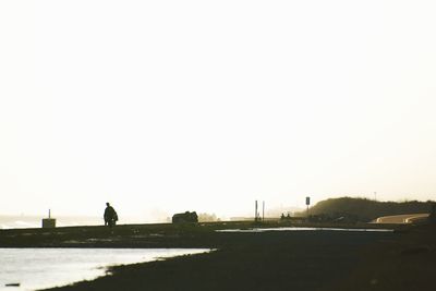 Rear view of silhouette man against clear sky