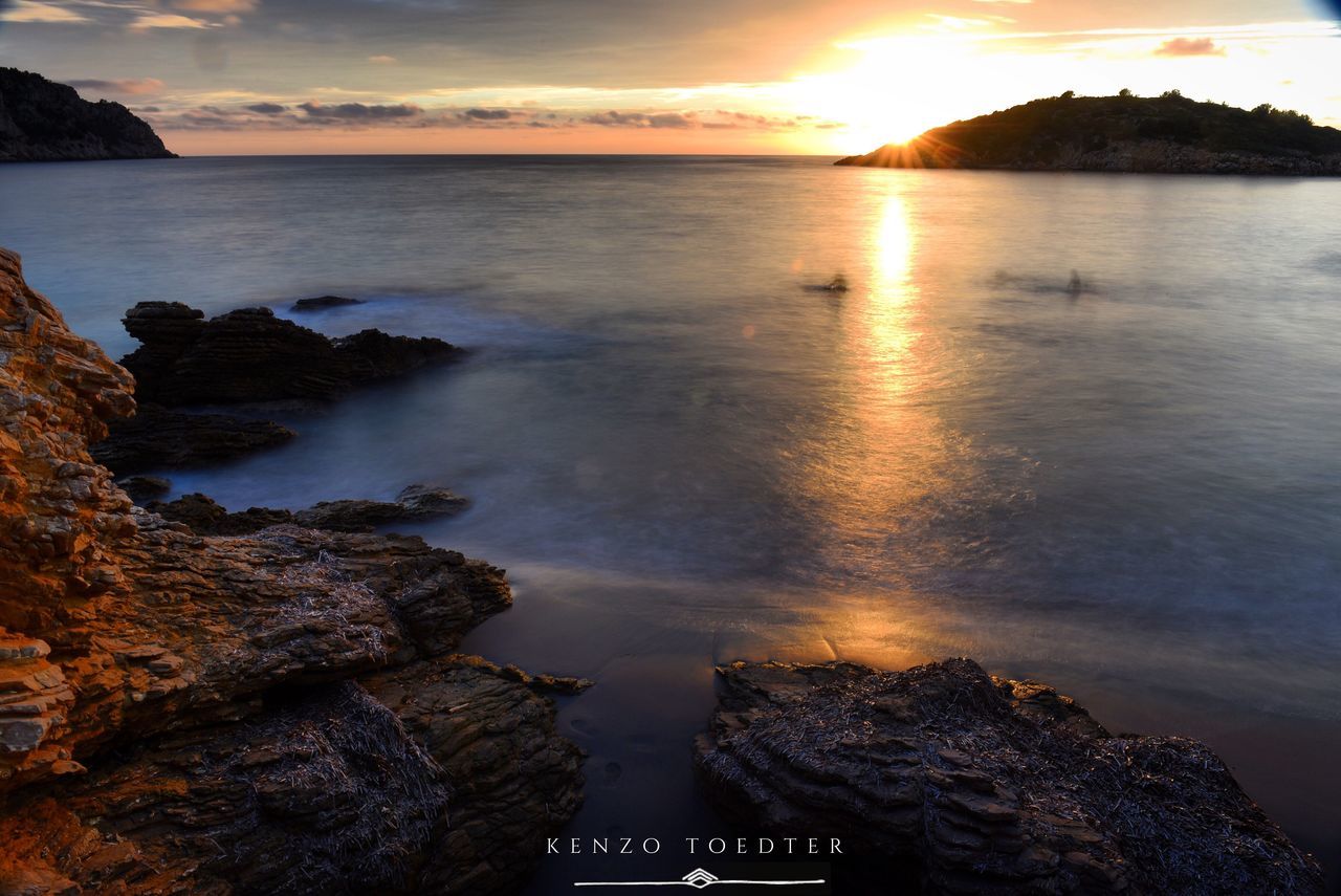 water, sunset, sea, scenics, beauty in nature, tranquil scene, sky, rock - object, tranquility, sun, reflection, nature, idyllic, cloud - sky, shore, sunlight, horizon over water, beach, sunbeam, outdoors