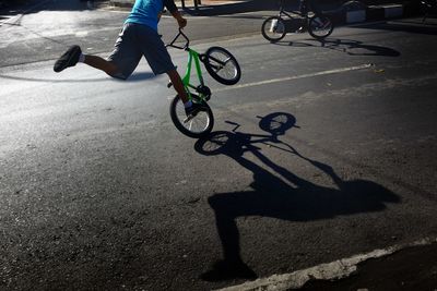 Low section of man riding bicycle on street