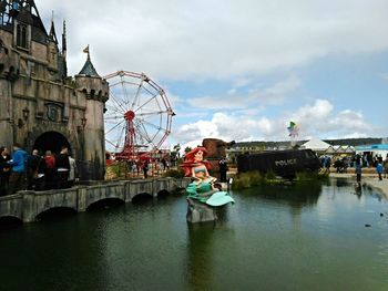 View of ferris wheel against cloudy sky