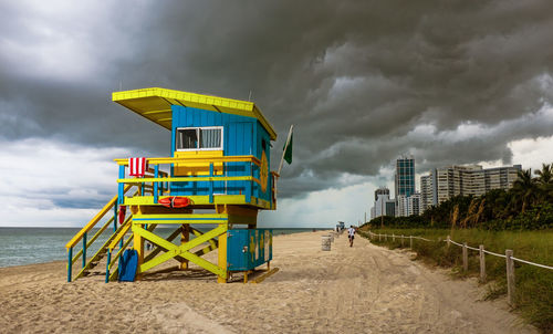 Lifeguard hut on beach against sky