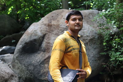 Portrait of young man standing on rock