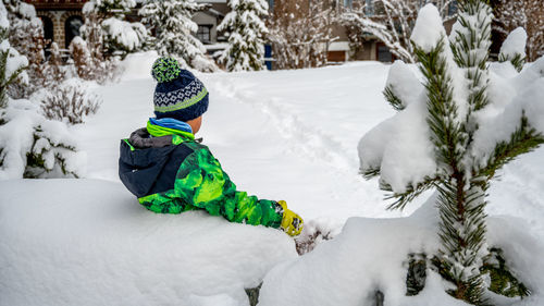 Rear view of child on snow covered field