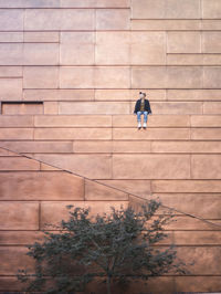 Low angle view of man sitting on building