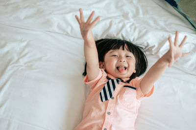 High angle view of baby girl lying on bed at home