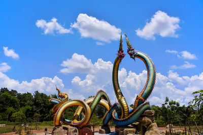  low angle twin stucco painted as a large serpent at pra kai keaw wang nakin,  udon thani, thailand.