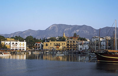 Scenic view of harbor by mountains against sky