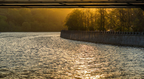 Scenic view of river against sky at sunset